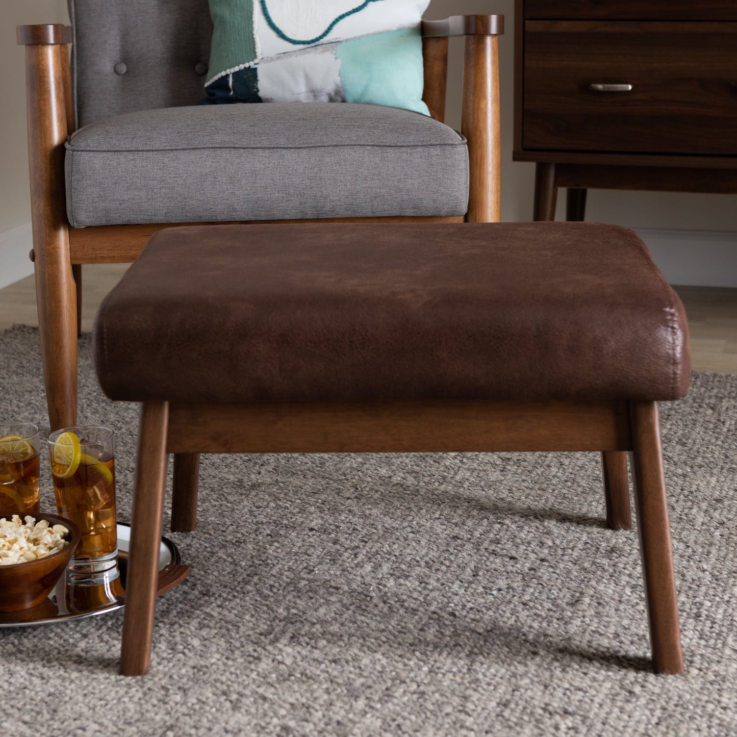 Bakari Mid-Century Modern Walnut Wood Dark Brown Distressed Faux Leather Ottoman by Bellamy Studios